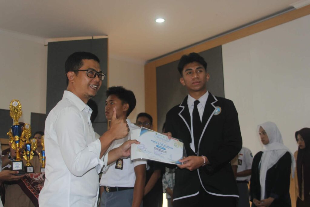 Kepala KCD Wilayah VII Asep Yudi Mulyadi menyerahkan piala LKS O2SN Kota Bandung 2026.